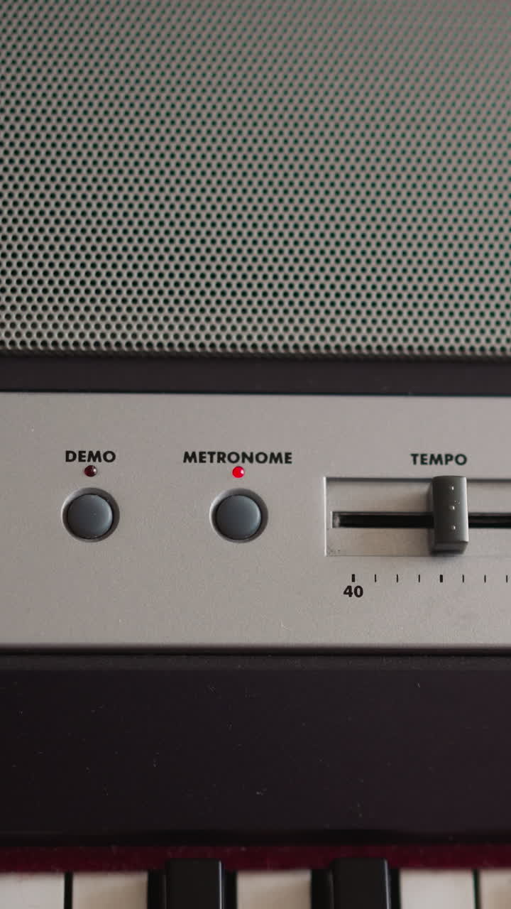 Child adjusts tempo moving lever and turns on metronome on electrical piano dashboard closeup. Kid prepares to play musical theme on digital instrument