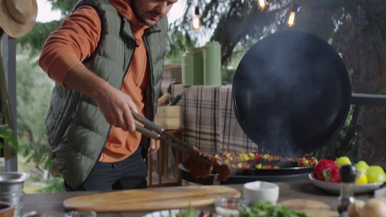Man Cooking Barbecue Meat on Outdoor Terrace