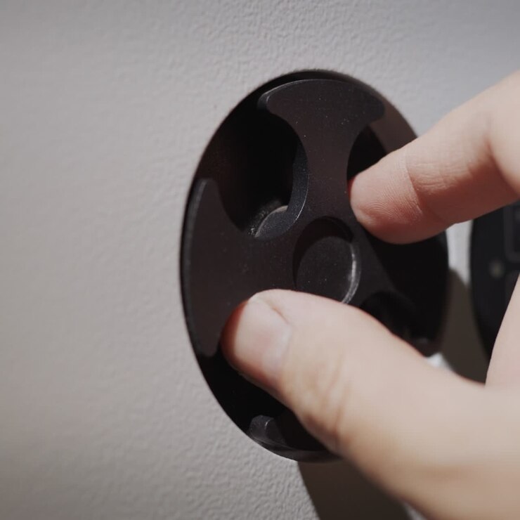 The man's finger enters the pin code on the lock of the safe then opens the door