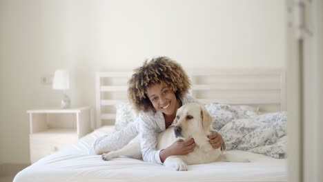 Frau-Hält-Einen-Hund-Auf-Einem-Bett