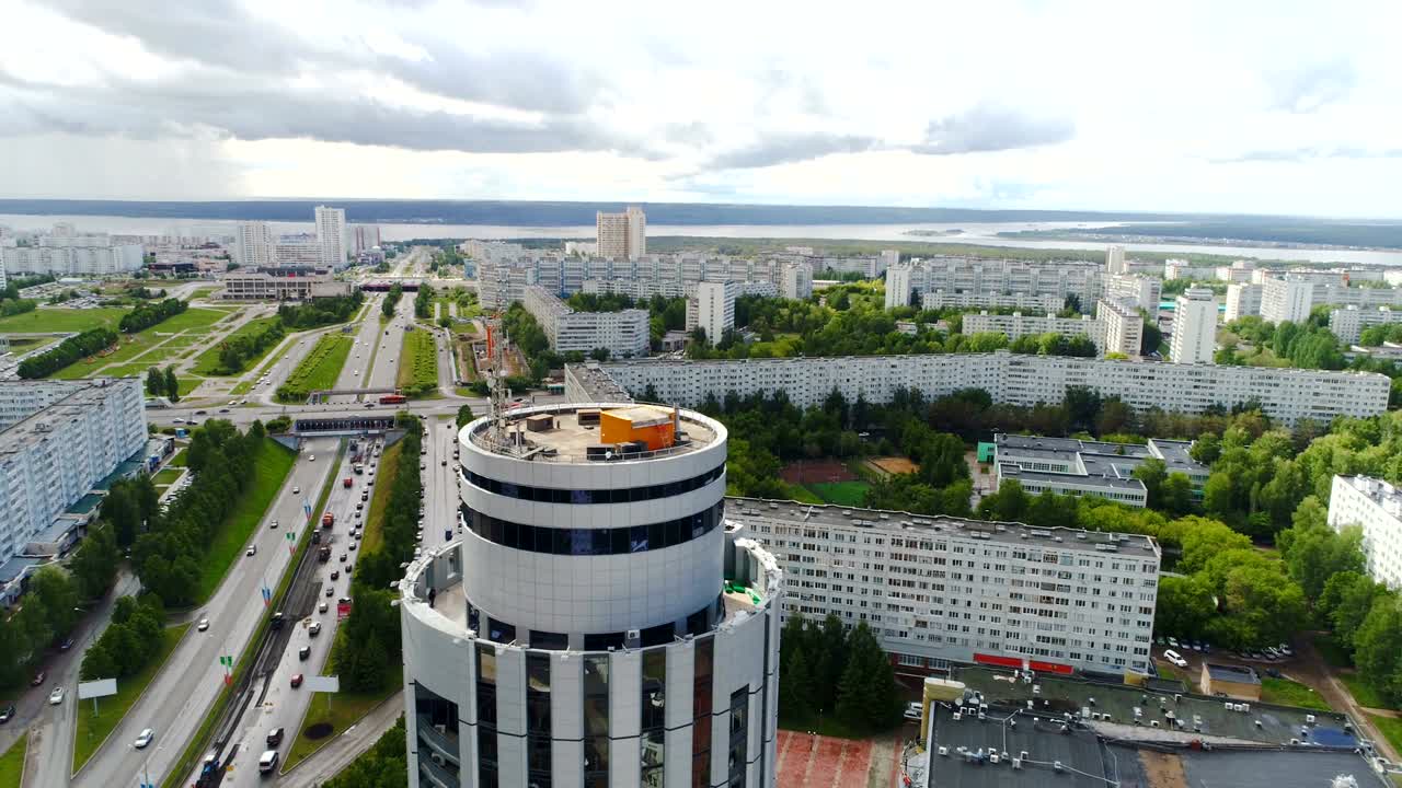 круглое центральное офисное здание с парковкой среди города