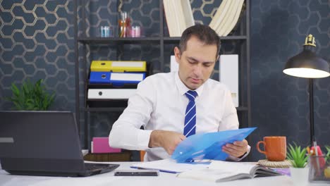 Businessman-working-looking-at-paperwork-files.