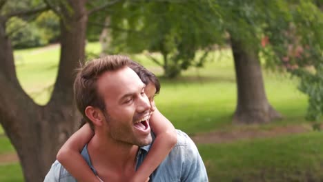 handsome father giving piggy back to his daughter