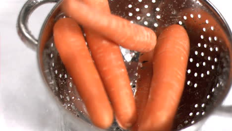 carrots falling into sieve in super slow motion