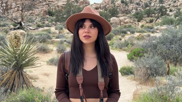Young Woman Walking and Observing Nature in Desert Landscape