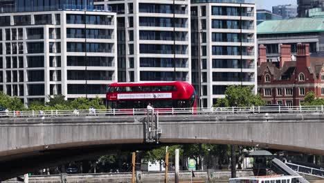 a red bus travels across a bridge