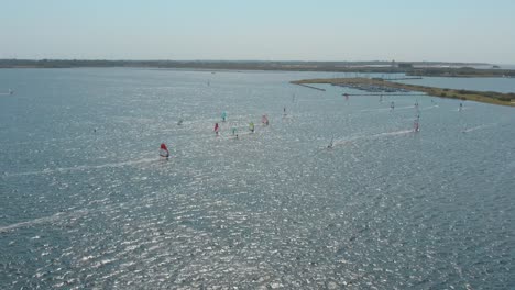 drone - toma aérea de muchos surfistas en un mar azul, ondulado y ventoso en un día soleado con nubes blancas en una isla, zelandia, países bajos, 30p