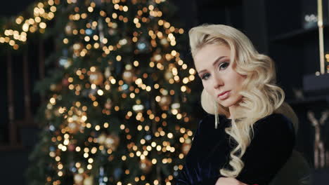 attractive young woman on background of blurry lights of christmas tree 1