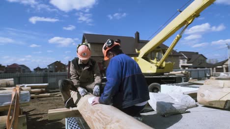 bauarbeiter montieren stämme für ein holzhaus