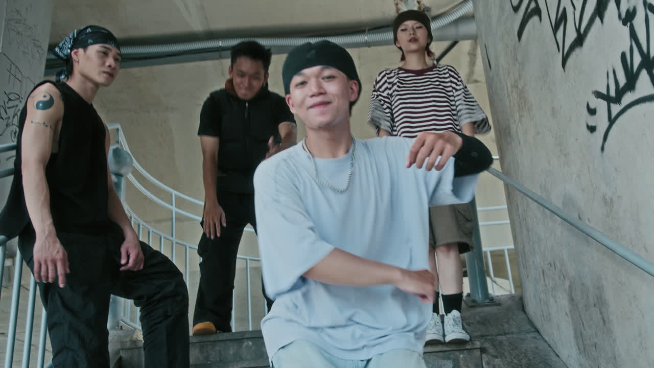Street Dancer Practicing Moves on Staircase with Crew