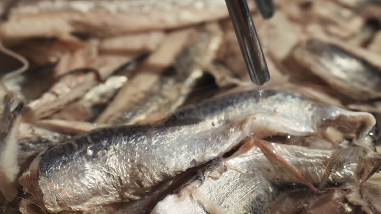 Fresh Sea sardines and Anchovy Fish and Mullus On Display On Ice On Market Store Shop. Seafood Fish Background, close up stand of small salty white fish.