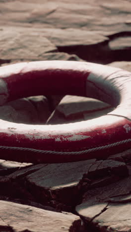 red life preserver on a rocky beach