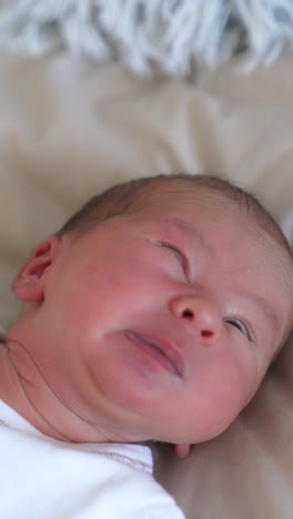 cute baby boy yawning. newborn child laying on a bed and yawning. adorable caucasian baby son.. vertical video