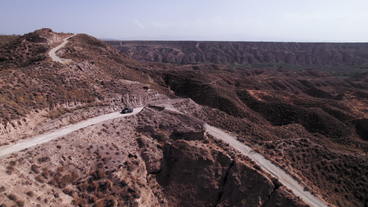 Car driving up the dirt road on the Gorafe desert, Spain