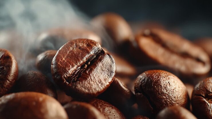 Eine Nahaufnahme gerösteter Kaffeebohnen, die ihre satten Farben und aromatischen Eigenschaften einfängt und die Essenz eines frisch gebrühten Kaffeeerlebnisses hervorruft.