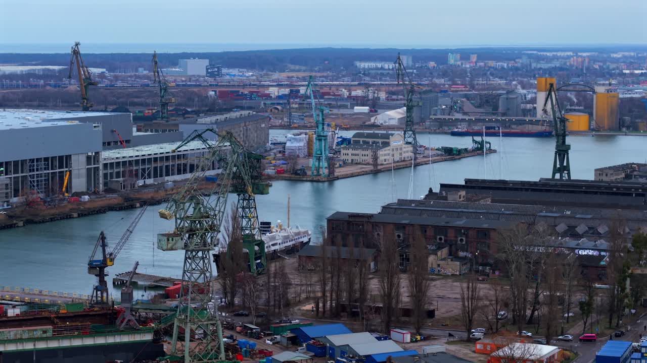 Aerial shot over Gdansk Shipyard showing cranes, warehouses, and construction areas