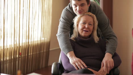 Un-Hijo-De-Treinta-Años-Abraza-A-Su-Madre-Mirando-A-La-Cámara.