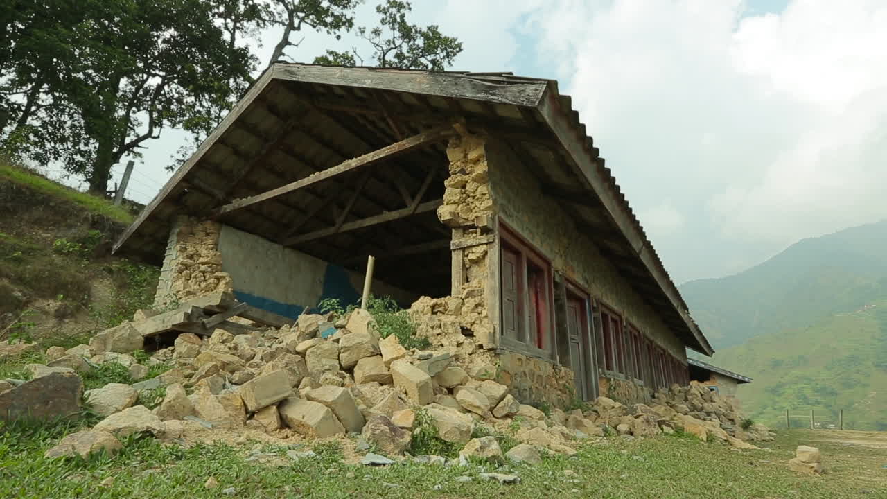 2015년 4월 네팔 지진 이후 폐허가 된 집 외부 옆에 있는 이동 샷