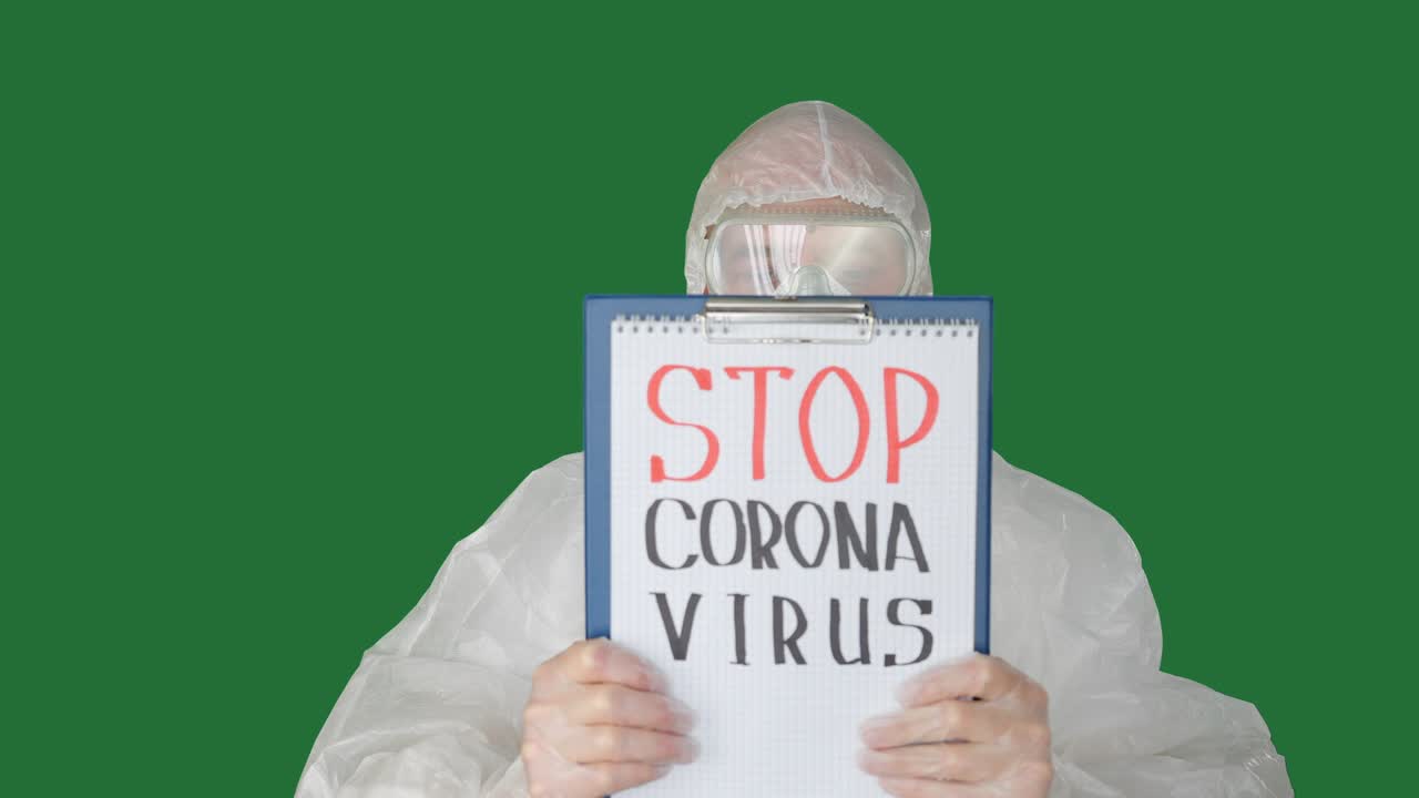 человек в защитном костюме показывает бумажку с надписью