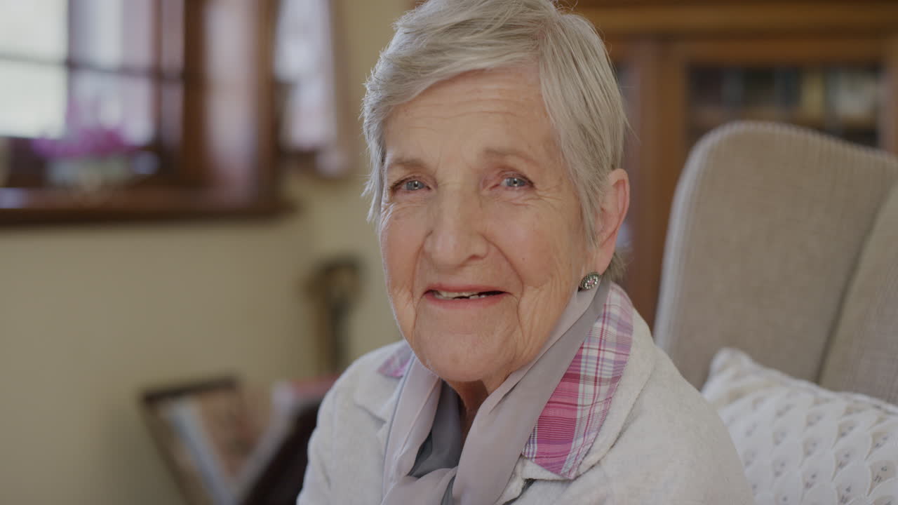 ritratto di una donna anziana felice che gode di uno stile di vita in pensione sorridendo allegra a casa seduta in salotto