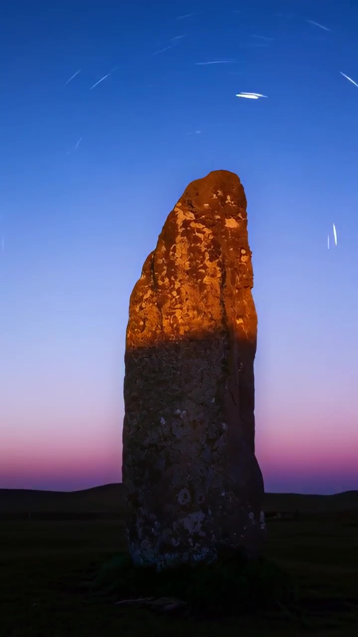 Dikey video: Alacakaranlık derinleşirken tarladaki bir taşı yakalayan hızlandırılmış kamera, yıldız izlerini gösteriyor.