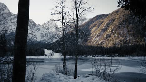 capture the beauty of fusine lake against a backdrop of towering mountains, illuminated by the golden glow of a setting sun. perfect for travel blogs, scenic vistas, and outdoor exploration.