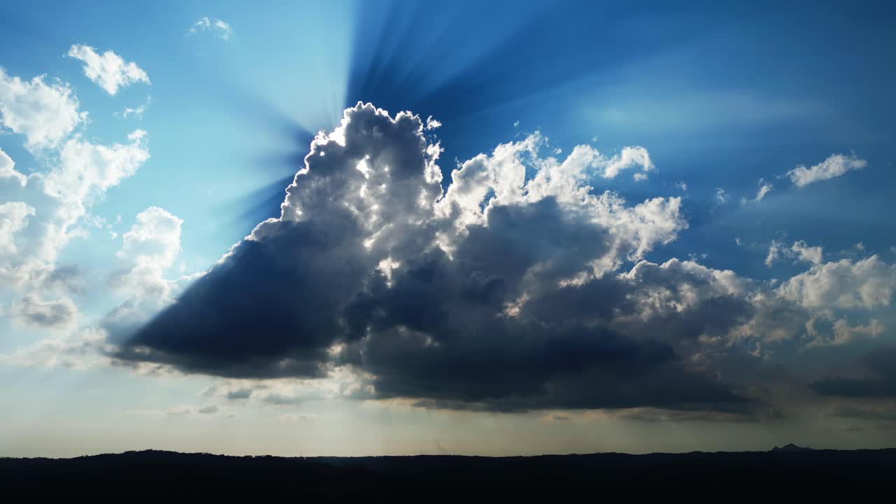 Céu diurno cinematográfico com nuvens dramáticas em movimento lento e raios de sol brilhantes criando uma poderosa atmosfera natural