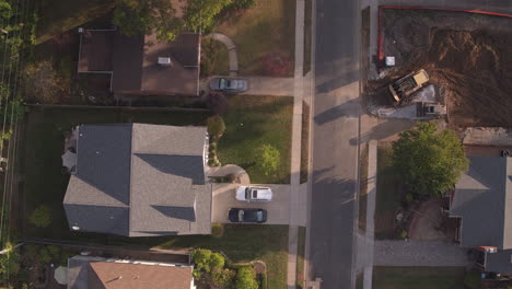 overhead view of suburban street at sunset with new construction camera pushes up the street