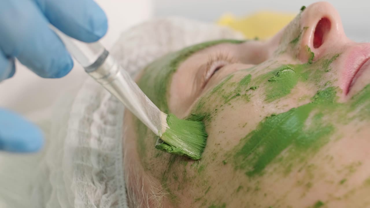 procedimientos profesionales de cuidado facial en la clínica de cosmetología moderna. aplicación de máscaras faciales