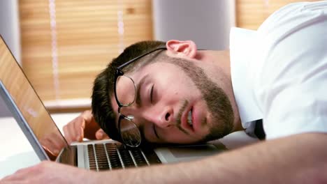 tired businessman sleeping on laptop at desk