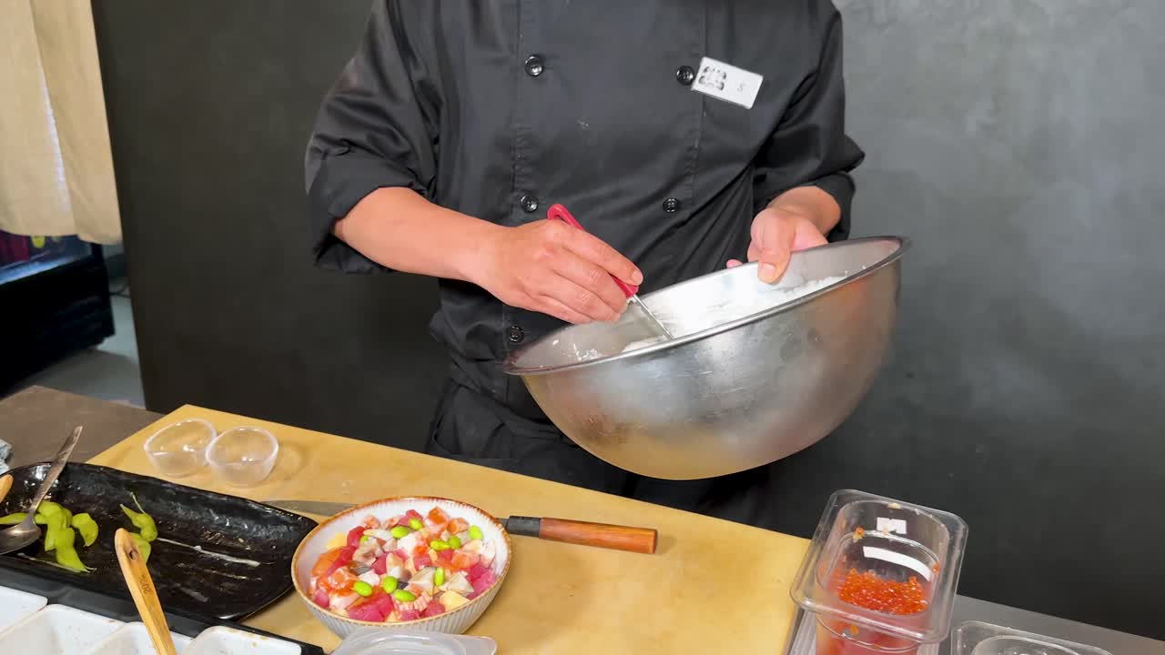 Uno chef professionista aggiunge della schiuma bianca a una zuppa di pesce in una cucina commerciale