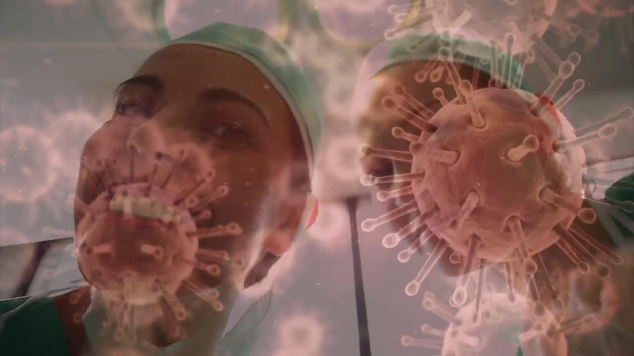 animación de células de covid-19 sobre diversos cirujanos que usan máscaras faciales en el quirófano