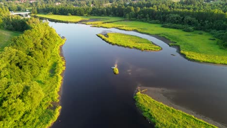 cinematic view from the drone as it moves away from the blue river that flows through the landscape