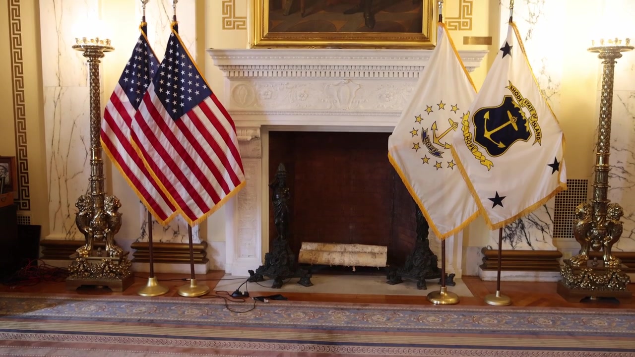 Sello estatal de Rhode Island, banderas estadounidenses y banderas estatales de Rhode Island en el capitolio estatal de Rhode Island con video de gimbal inclinándose hacia arriba