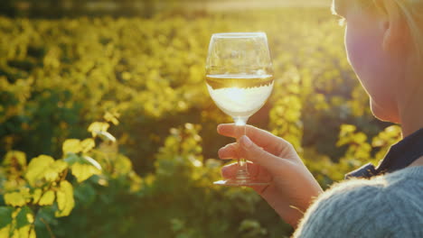 mujer vierte vino blanco en una copa de degustación privada en la bodega