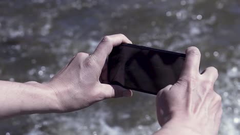 person taking a picture of water