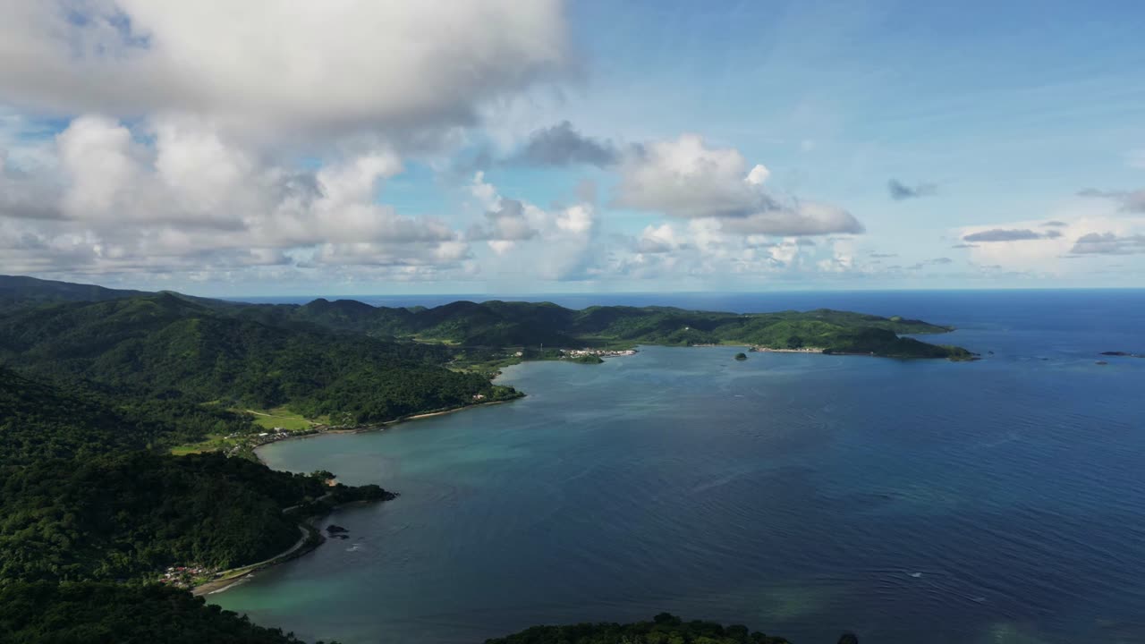 Panoramic aerial time-lapse of tropical island coastline and cove with clouds passing at Baras, Catanduanes, Philippines during daytime
