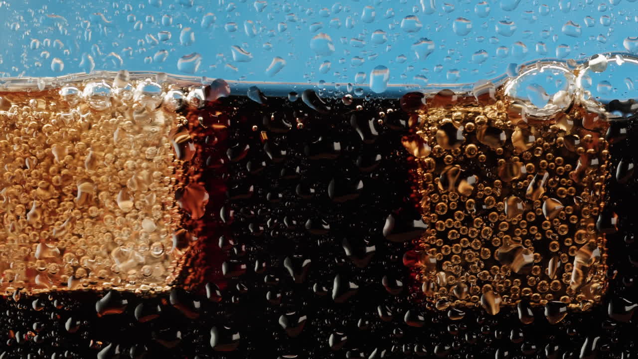 Close-up of a cold soda with ice cubes and condensation