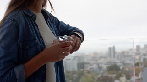holding glass cup, woman relaxing on balcony with city view, at home, copy space