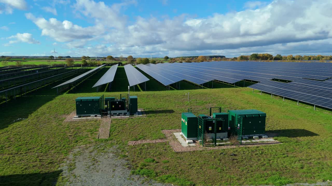 Dronevideo fra luften, der viser solpaneler, som producerer vedvarende elektricitet til den nationale energiinfrastruktur nær Nottingham, UK