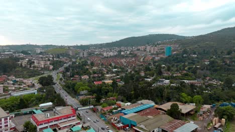dolly in aerial view of a small mountain village surrounded by vegetation