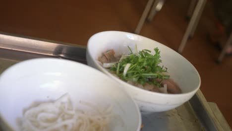 ingredients being added for traditional vietnamese pho beef noodle soup in local restaurant