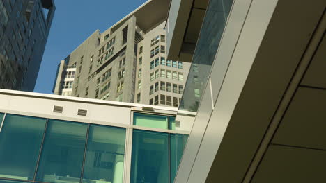 Modern-urban-architecture-with-sleek-glass-facades-and-towering-apartment-buildings-against-clear-sky