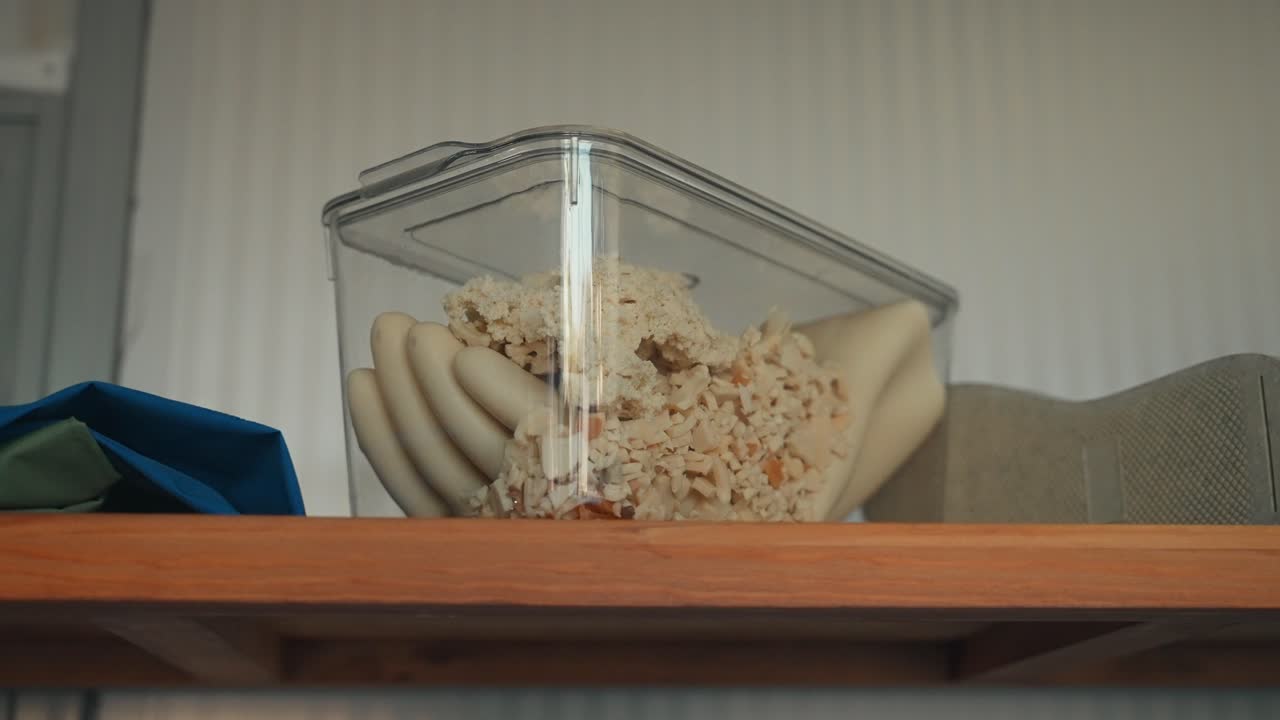 Container of gloves and recycled rubber material in factory setting