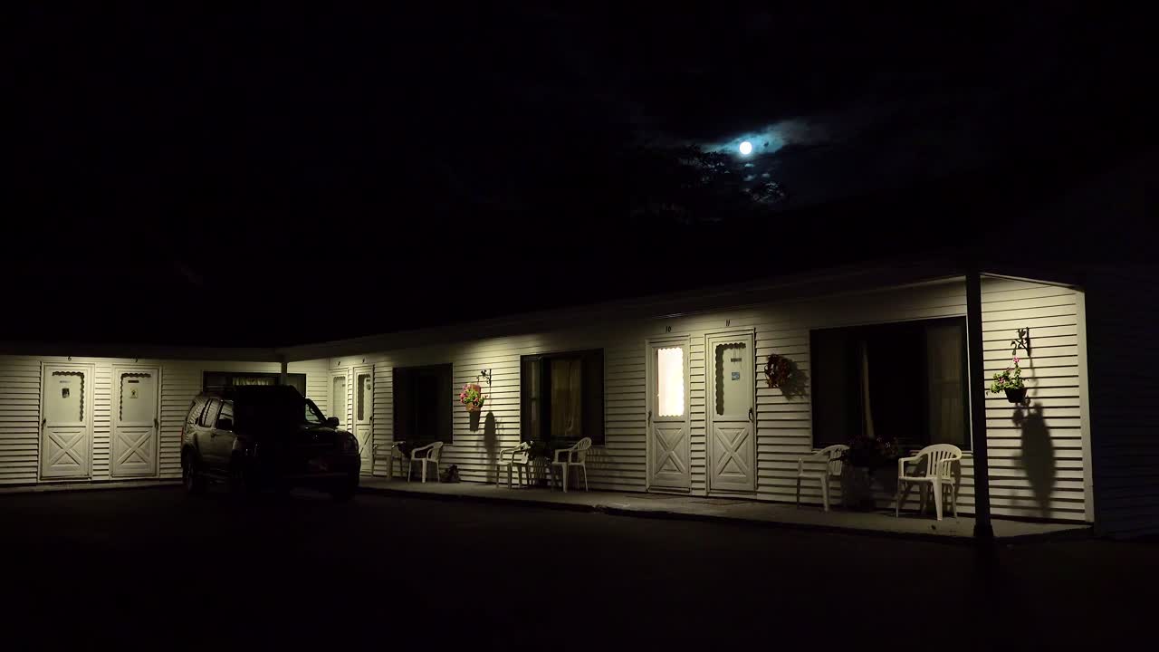 Plan d'ensemble d'un motel en bord de route sous une pleine lune la nuit 3