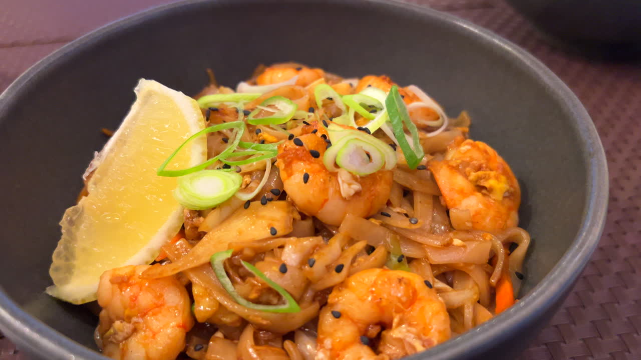 전통적인 pad thai wok 라면과 새우, 봄 양파, 레몬 조각, 태국 레스토랑, 맛있는 아시아 음식, 4k