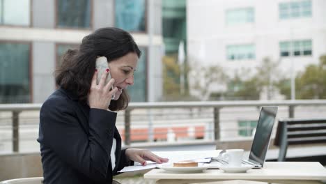 businesswoman using digital devices in cafe