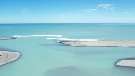 aerial traverse parallel to exit of beautiful turquoise-colored rakaia river into ocean