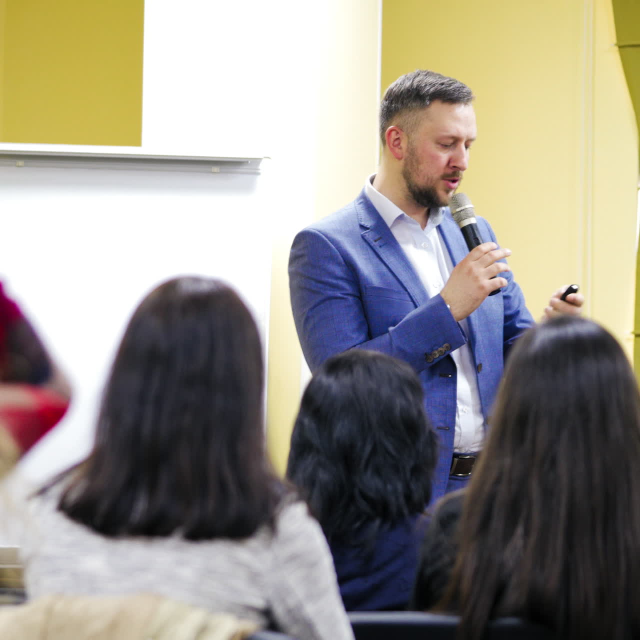 Executive leader in suit at business conference. Speaker man is giving a talk on podium at business meeting for the audience.