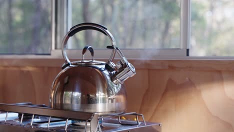 whistle kettle boils in the morning light of tiny cabin